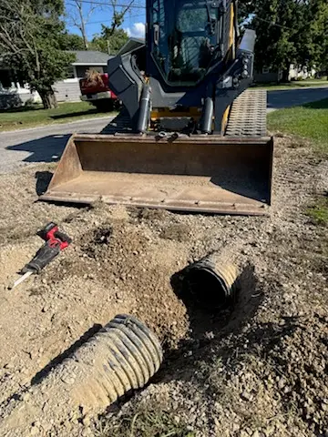Drainage pipe cut and set with a compact track loader by Foil Land Services